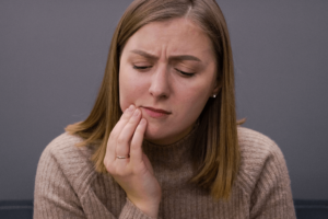 woman experiencing mouth pain but is anxious about the dentist