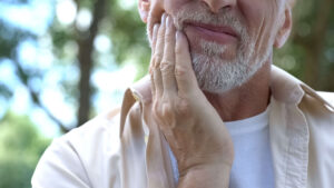 man holding his jaw due to pain