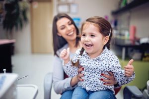 children at our dental practice in Maidstone, Kent smiling with mother