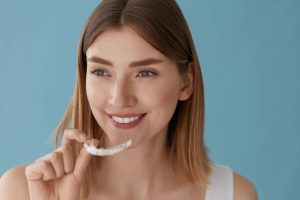 woman at Maidstone dental practice inserting Invisalign braces for treating gaps