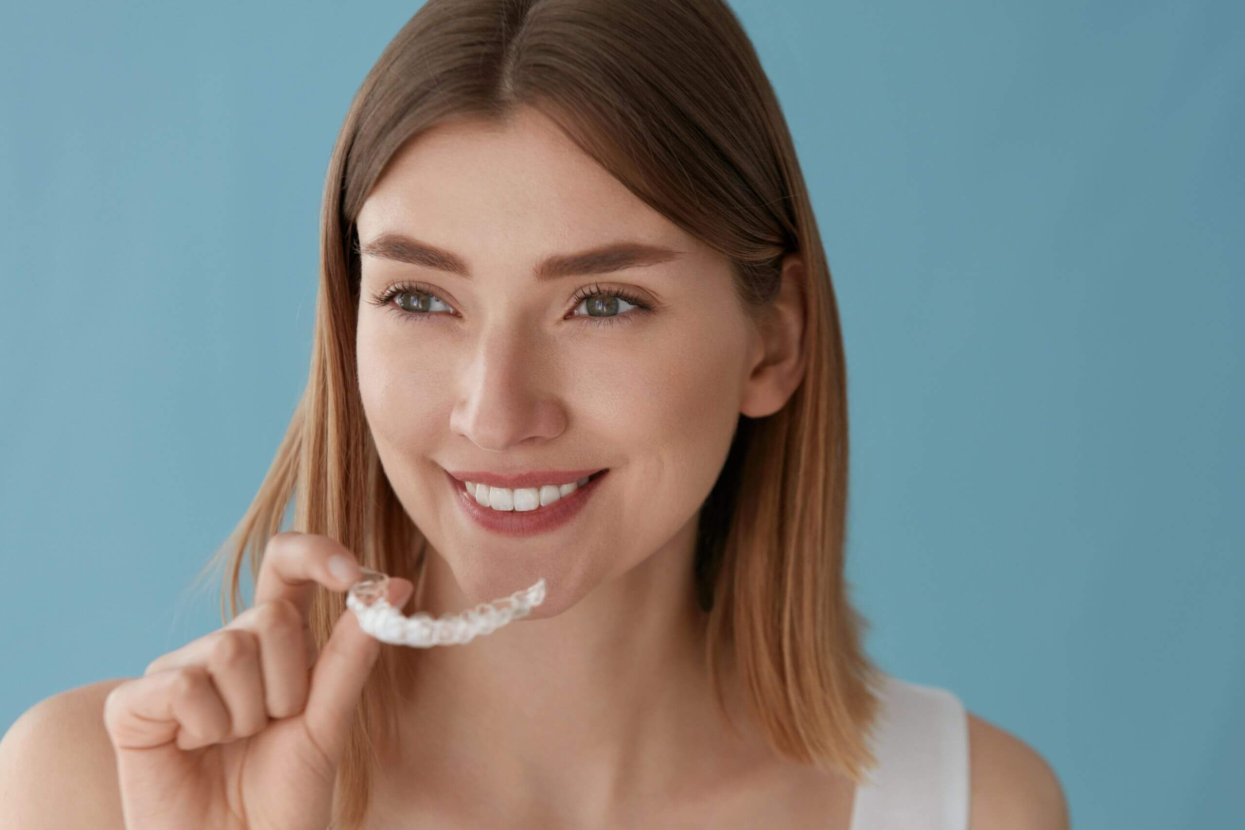 woman at Maidstone dental practice inserting Invisalign braces for treating gaps