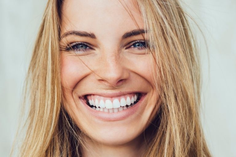Blonde woman smiling with white teeth