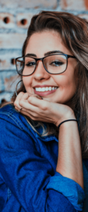 woman with glasses smiling with whitened teeth