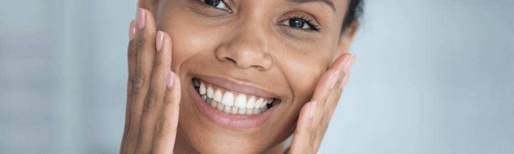 woman with dental implants in maidstone, kent holding face