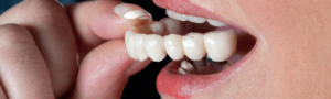 Woman putting in dentures in Maidstone dental practice