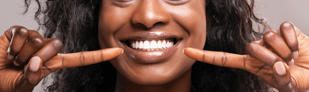 woman with teeth whitening in maidstone, kent pointing at teeth